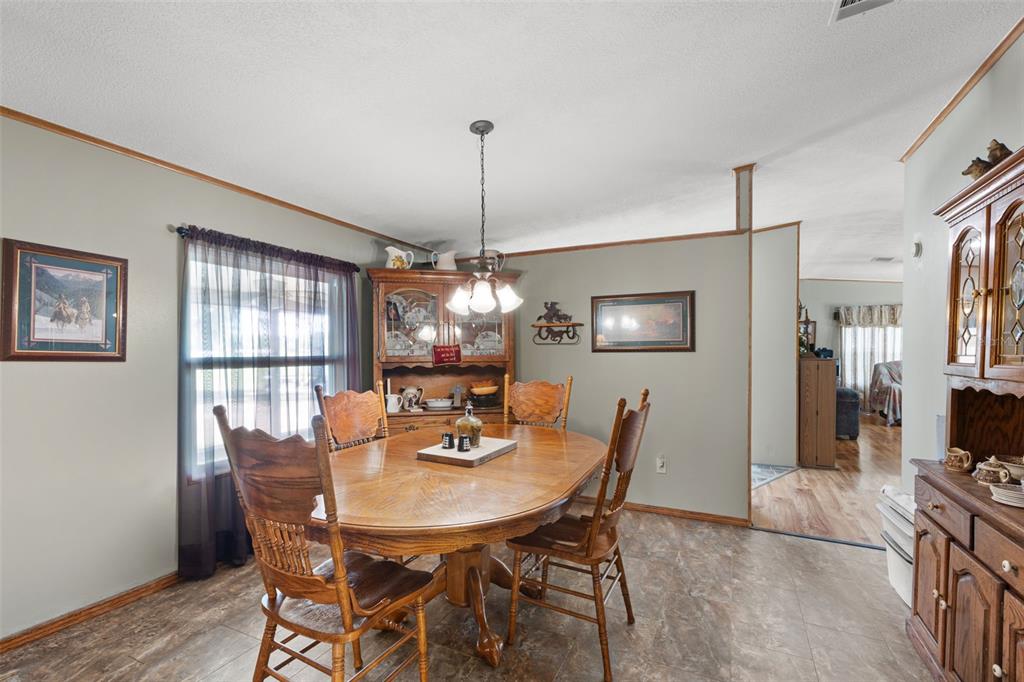 6689 Southeast 55th Street Trenton, FL 32693 - Photo 10 of 83 a dining room with furniture a chandelier and wooden floor