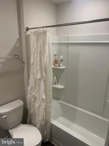 a bathroom with a toilet and a shower