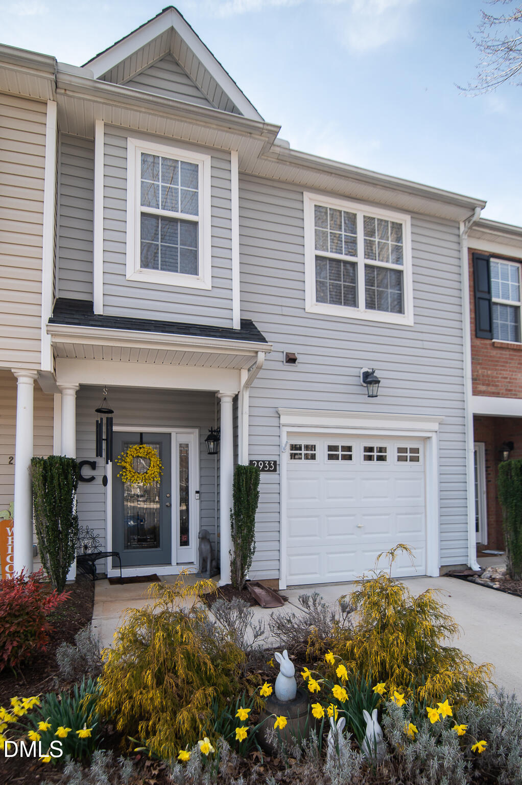a view of a house with potted plants and a tree