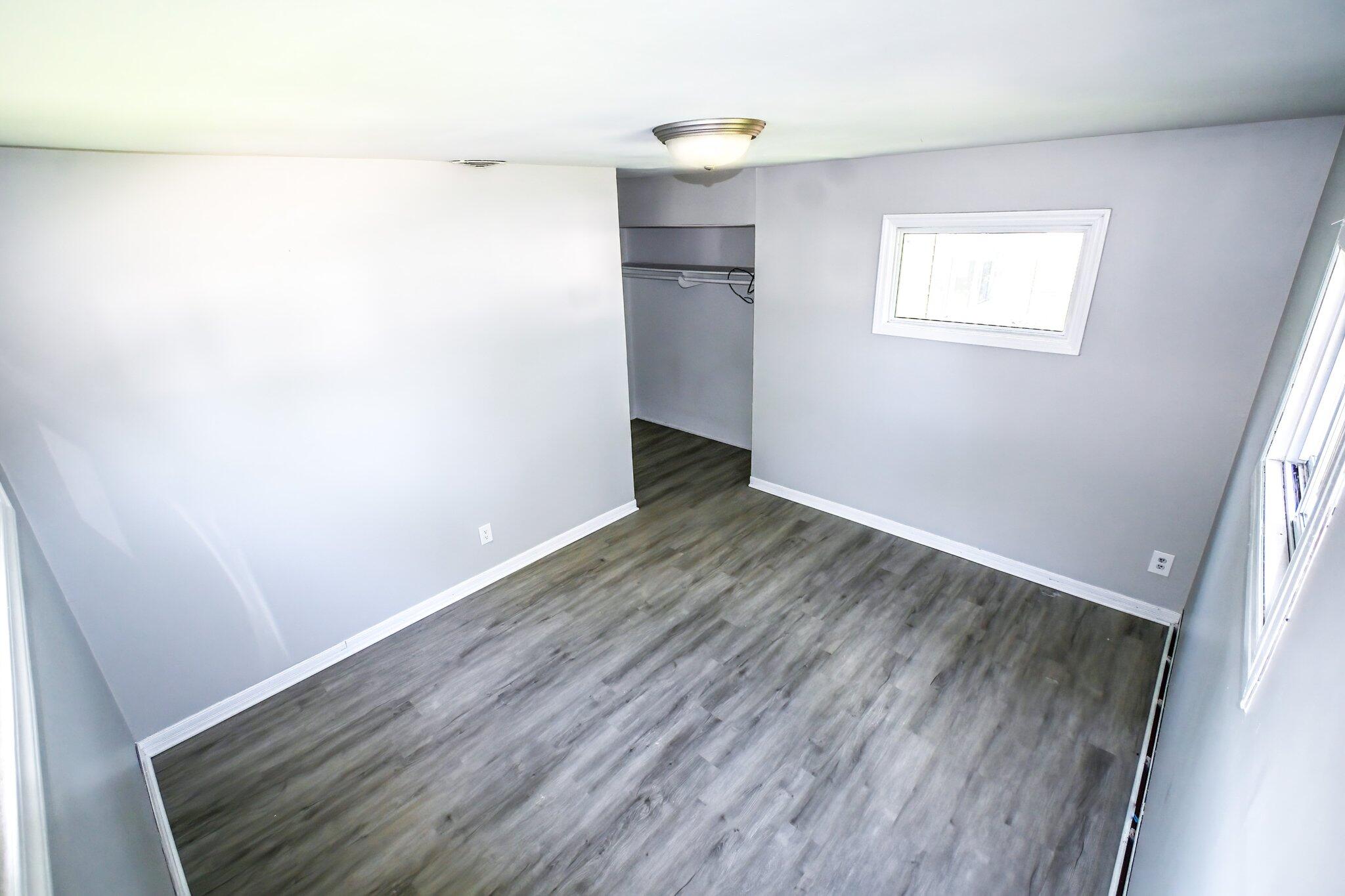 7828 Chestnut Avenue Hammond, IN 46324 - Photo 13 of 23 a view of an empty room with wooden floor and a window