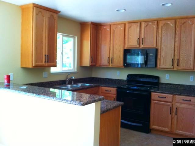 1455 Locksley Way Reno, NV 89503 - Photo 2 of 5 a kitchen with stainless steel appliances granite countertop a stove a sink and a microwave