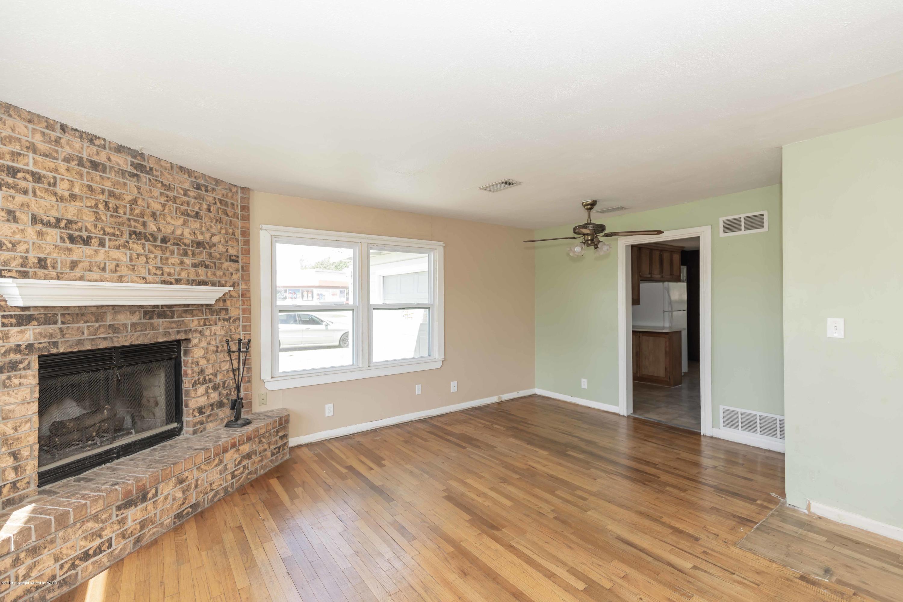 3524 Lometa Drive Amarillo, TX 79109 - Photo 4 of 21 a view of an empty room with wooden floor fireplace and a window
