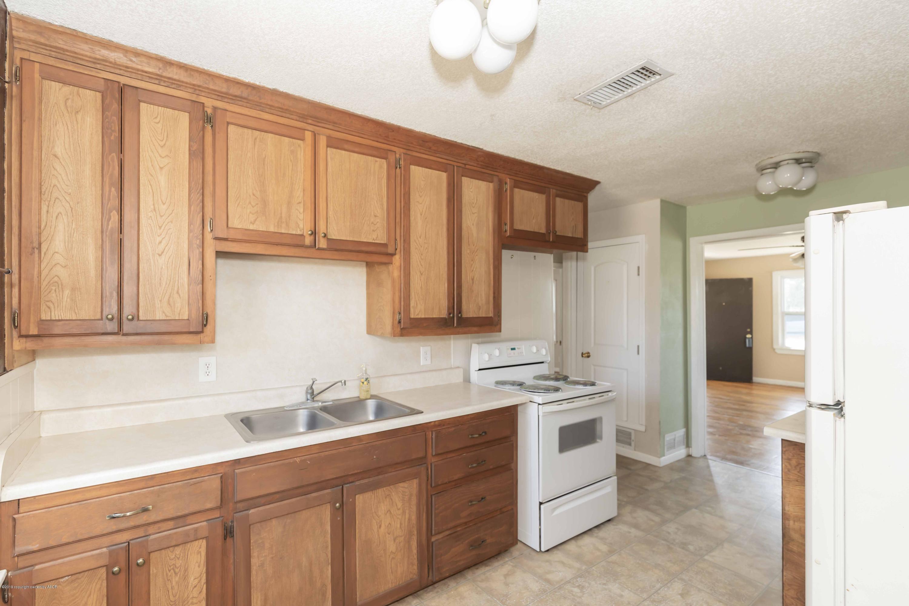 3524 Lometa Drive Amarillo, TX 79109 - Photo 8 of 21 a kitchen with white cabinets and white appliances