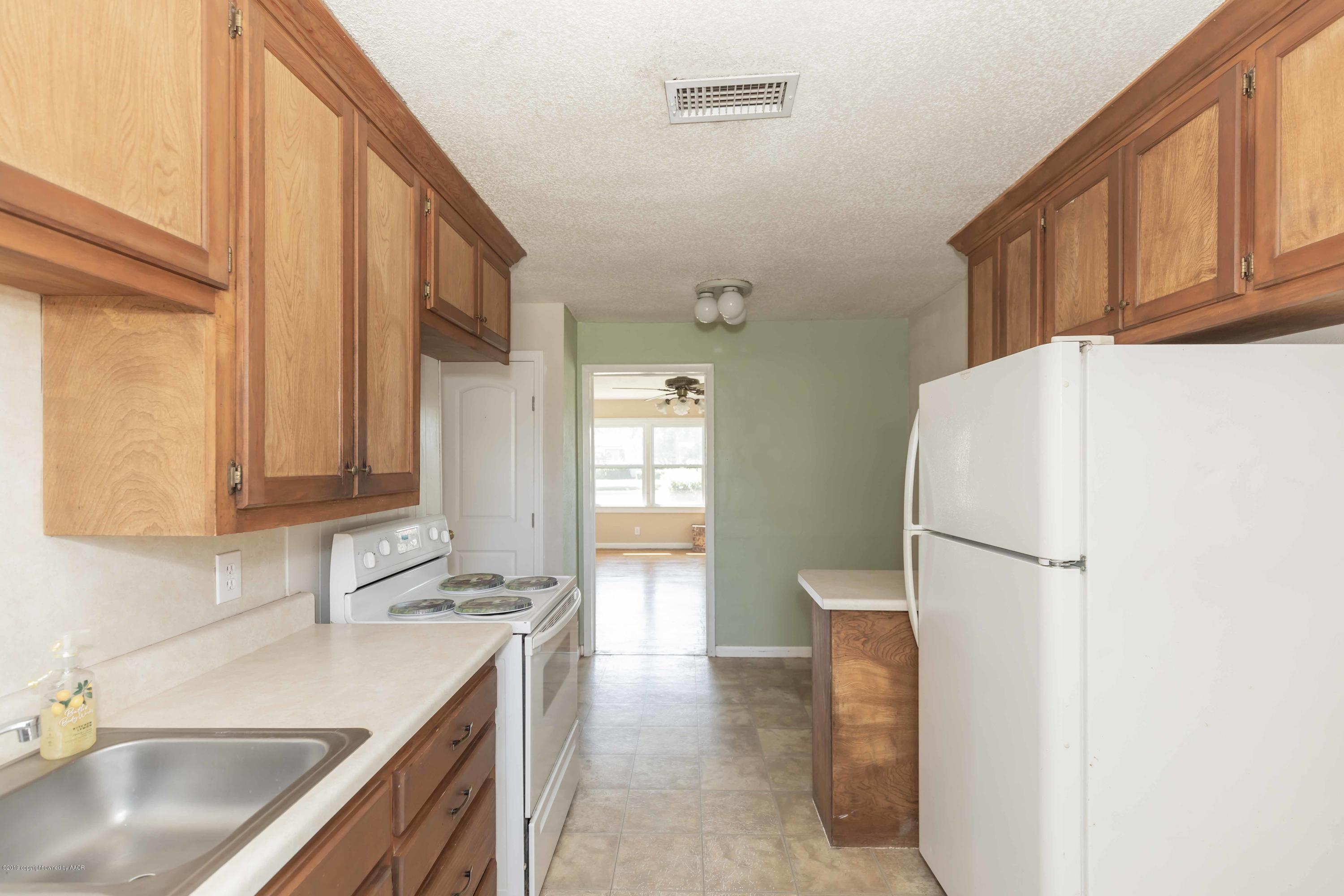 3524 Lometa Drive Amarillo, TX 79109 - Photo 9 of 21 a kitchen with a sink a refrigerator and cabinets