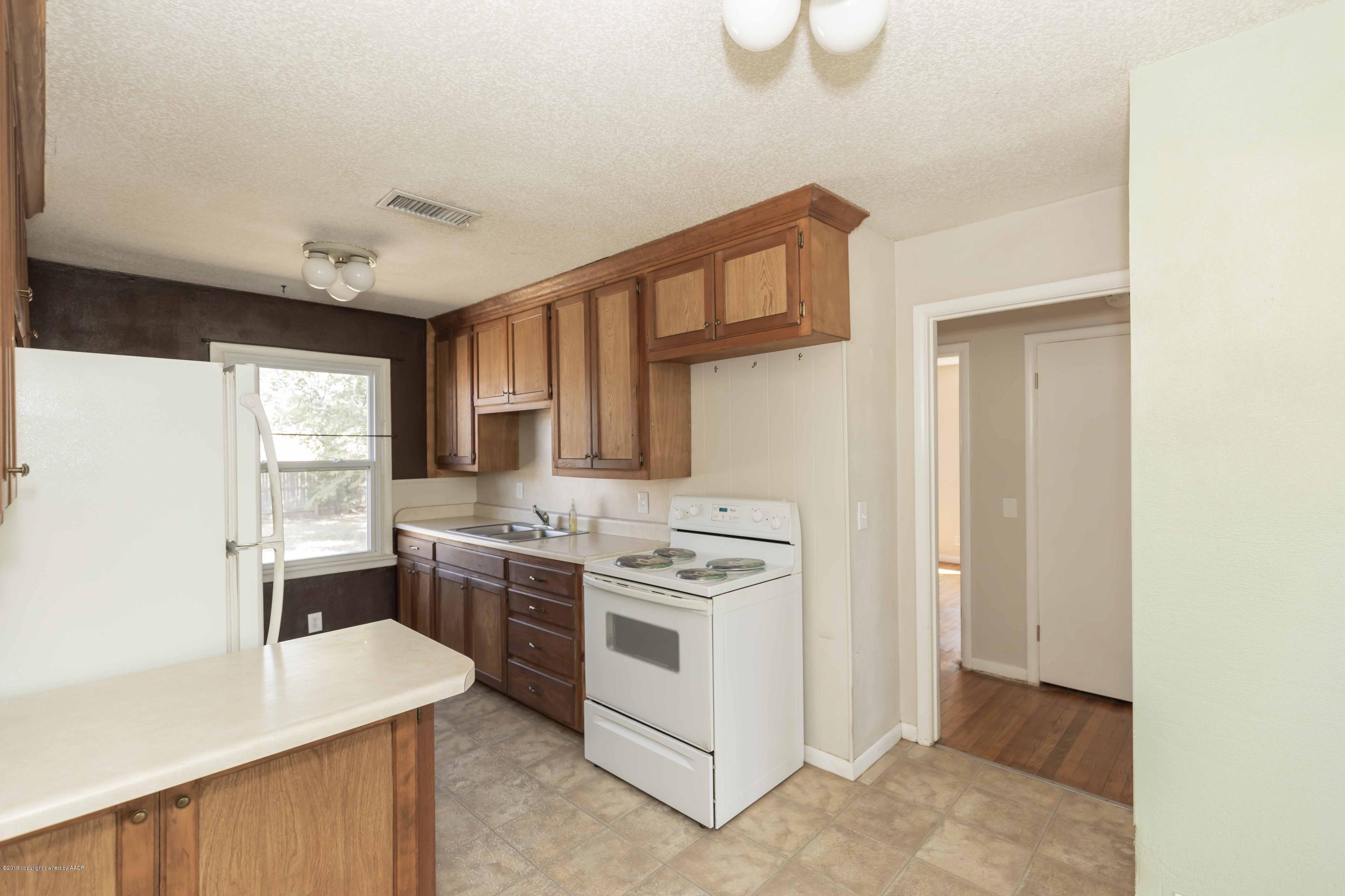 3524 Lometa Drive Amarillo, TX 79109 - Photo 10 of 21 a kitchen with a stove a sink and a refrigerator