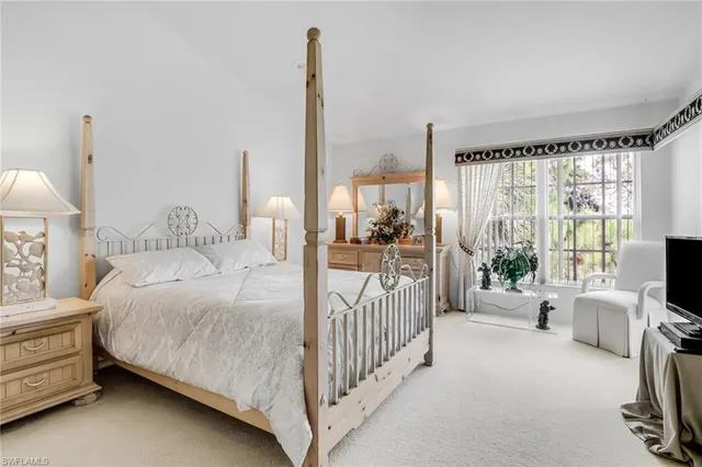 a bedroom with a bed and a flat tv screen on dresser