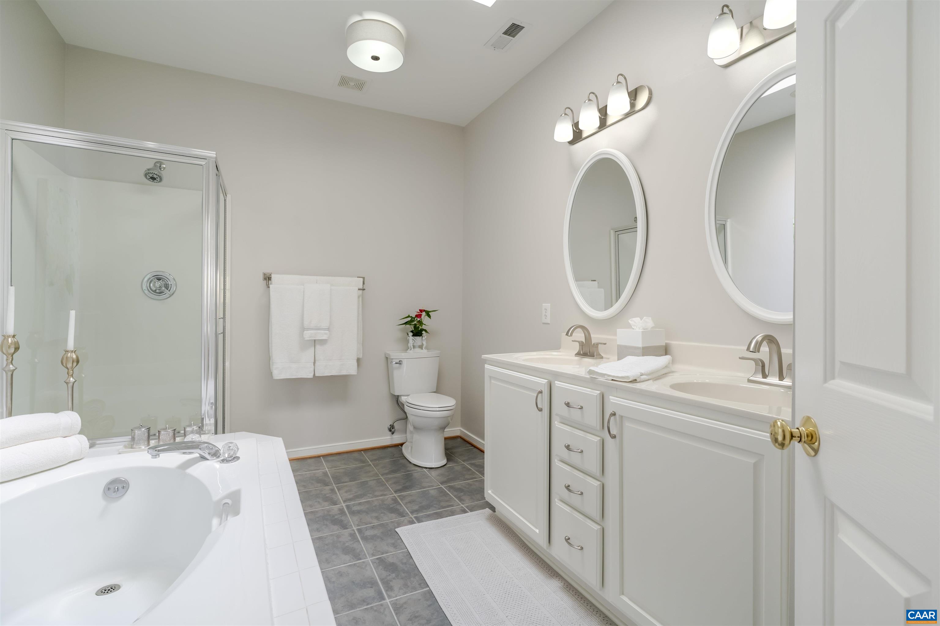 1322 Stonegate Court Crozet, VA 22932 - Photo 20 of 39 a spacious bathroom with a double vanity sink a toilet and a mirror