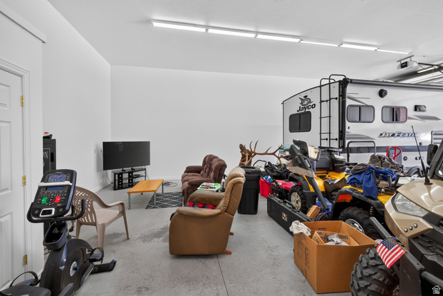 4635 East Sunny Acres Lane Moab, UT 84532 - Photo 37 of 56 Spacious garage area featuring a concrete floor, white walls, and overhead fluorescent lighting
