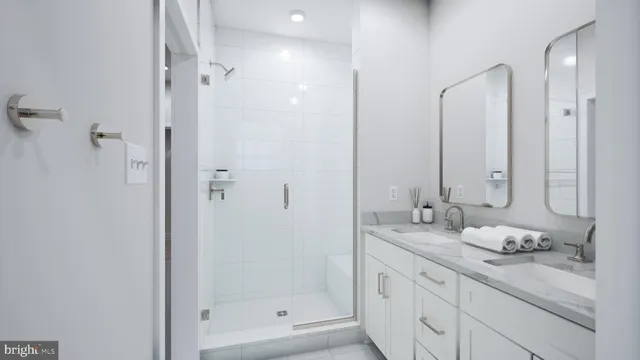 a bathroom with a granite countertop sink two mirror and shower