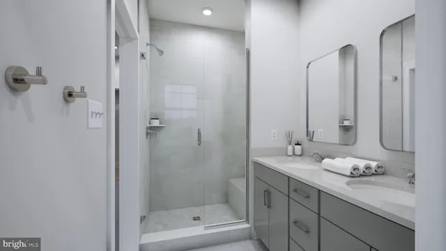 a bathroom with a granite countertop sink two mirror and shower