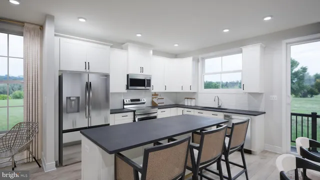 a kitchen with stainless steel appliances a table chairs microwave and refrigerator