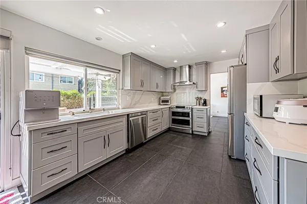 a kitchen with cabinets stainless steel appliances a refrigerator and cabinets