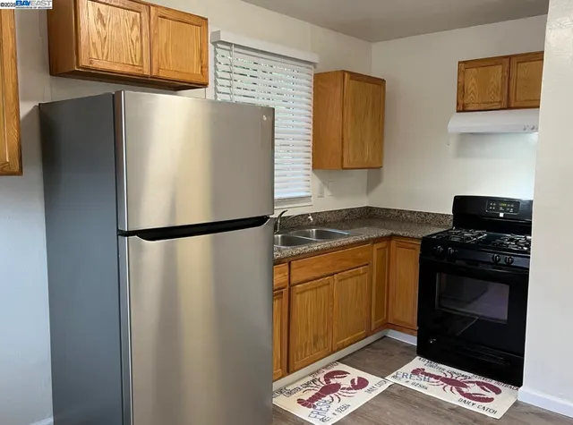 a kitchen with stainless steel appliances granite countertop a refrigerator a stove a sink and a microwave