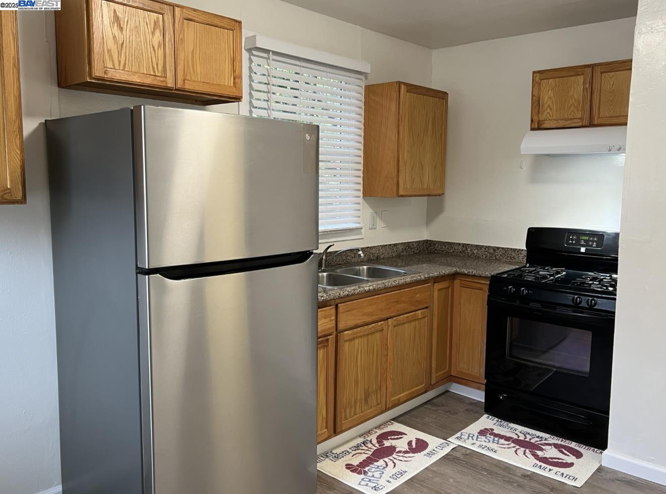 a kitchen with stainless steel appliances granite countertop a refrigerator a stove a sink and a microwave