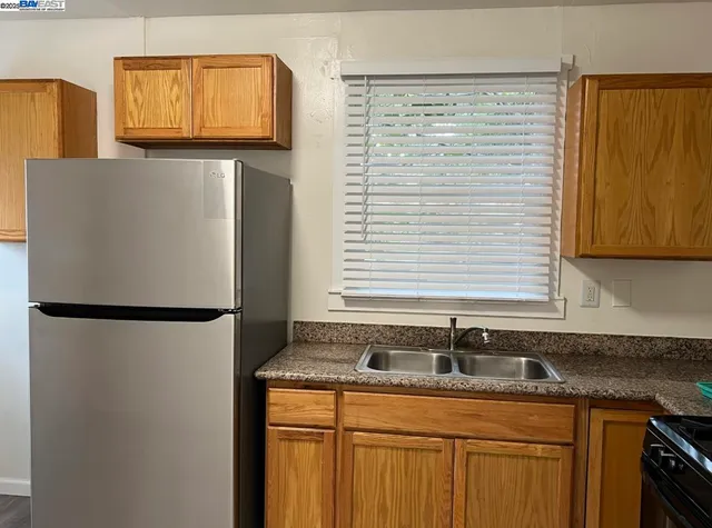 a kitchen with granite countertop a sink and a refrigerator