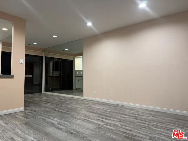 an empty room with wooden floor and entryway