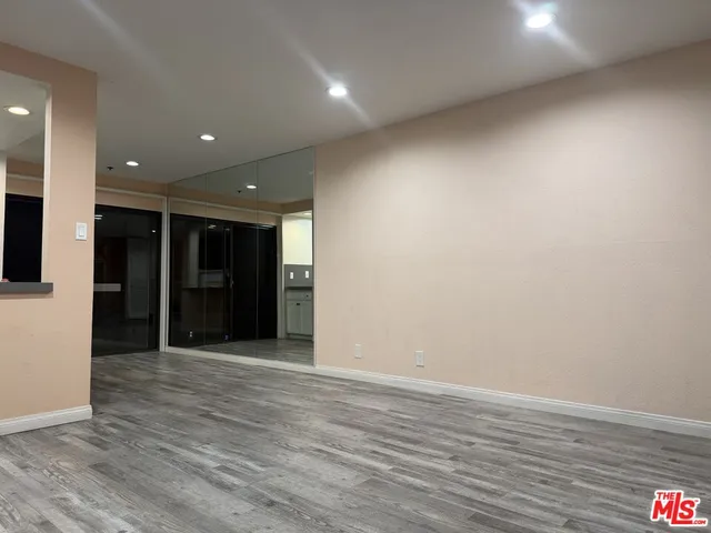 an empty room with wooden floor and entryway
