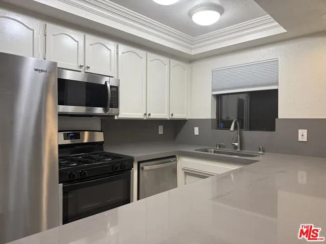a kitchen with a sink and stainless steel appliances