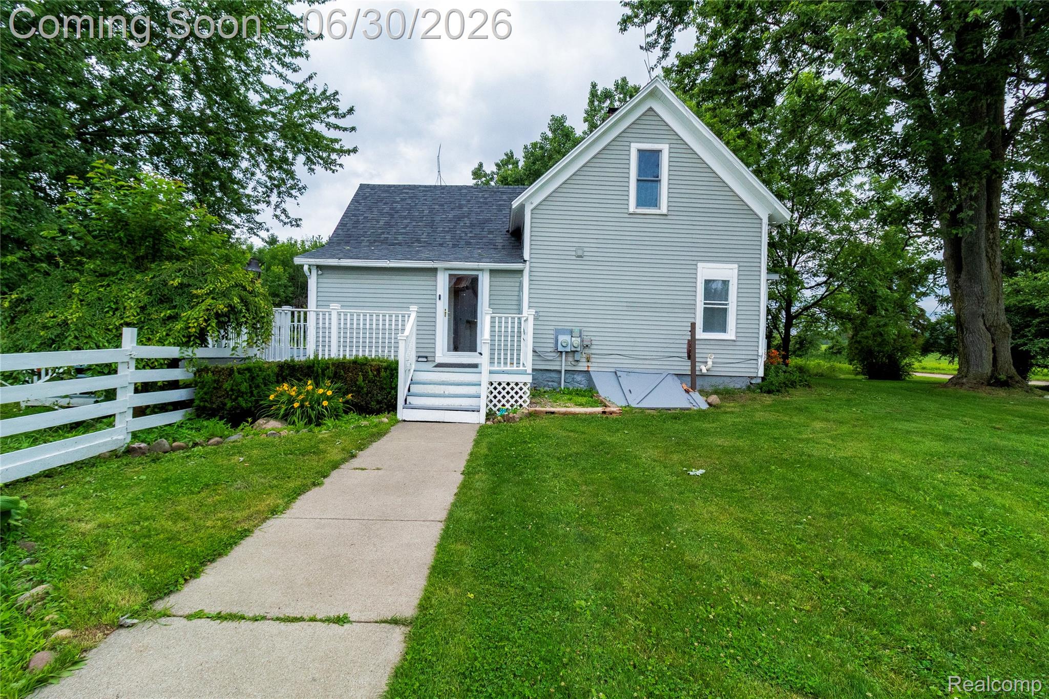 8150 Norman Road Imlay City, MI 48444 - Photo 5 of 58 Light gray siding exterior with white trim and a dark shingled roof