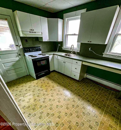 a kitchen with a sink a stove and cabinets