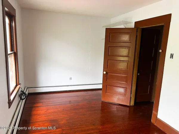 an empty room with wooden floor and closet