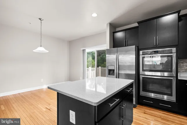 a kitchen with stainless steel appliances granite countertop a refrigerator a stove and a sink