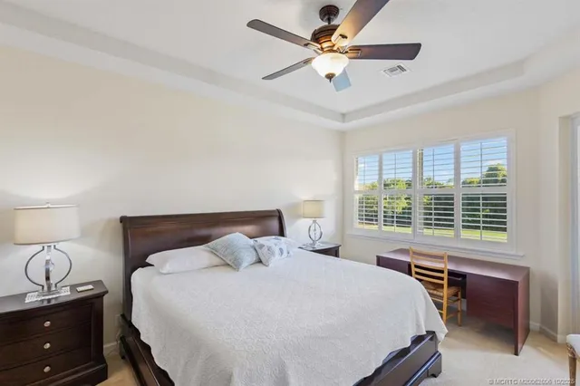 a bedroom with a bed and dresser with wooden floor