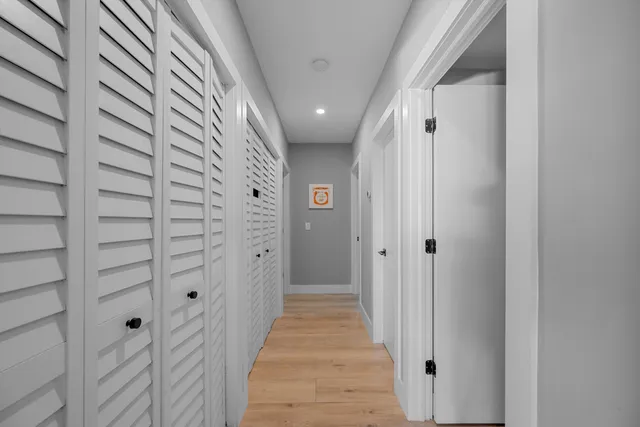 a view of a hallway with wooden floor and staircase