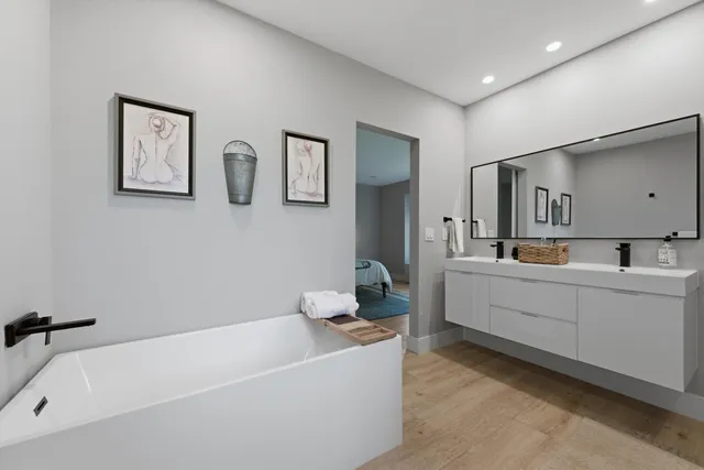 a bathroom with a bathtub a sink and mirror