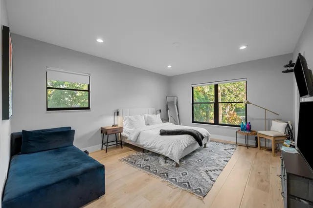 a bedroom with furniture and a large window