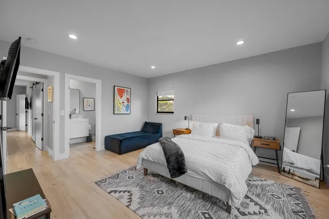 a spacious bedroom with a bed a couch and a computer on desk