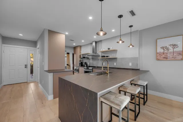 a kitchen with stainless steel appliances granite countertop a refrigerator a sink and a stove