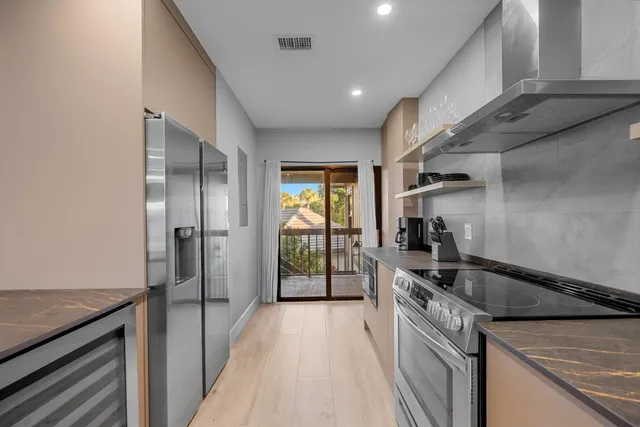 a kitchen that has a sink a stove and a refrigerator