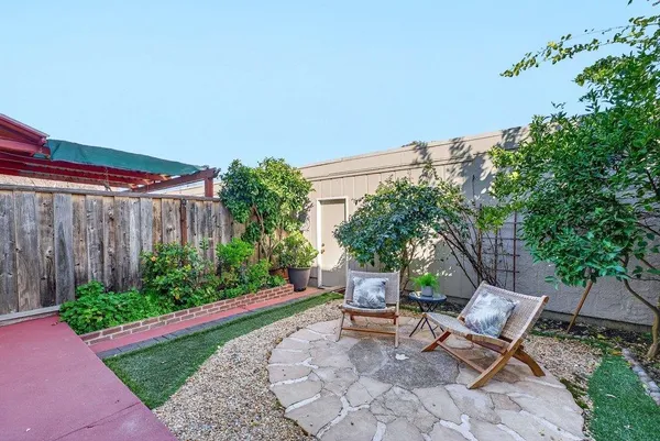 a view of a house with backyard and sitting area