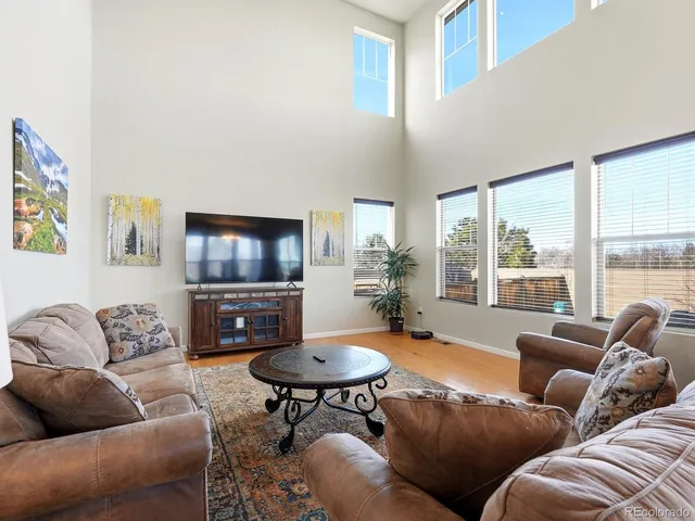 a living room with furniture a flat screen tv and a large window