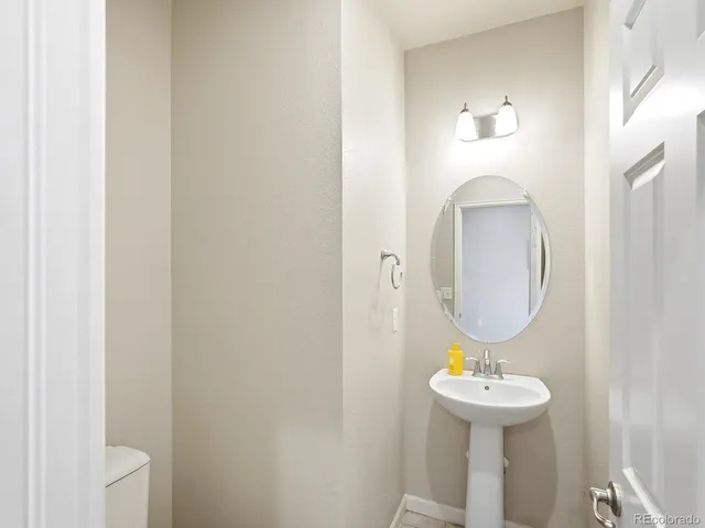 a bathroom with a toilet a sink and mirror