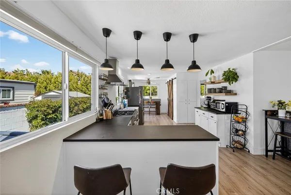 a kitchen with stainless steel appliances granite countertop a stove a sink dishwasher and a dining table with garden view
