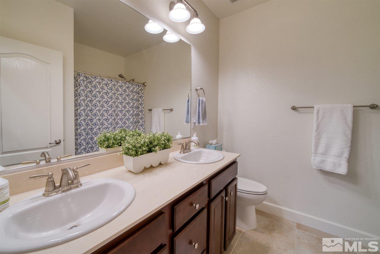 10380 Gold Mine Drive Reno, NV 89521 - Photo 15 of 23 a bathroom with a granite countertop sink a large mirror and a toilet
