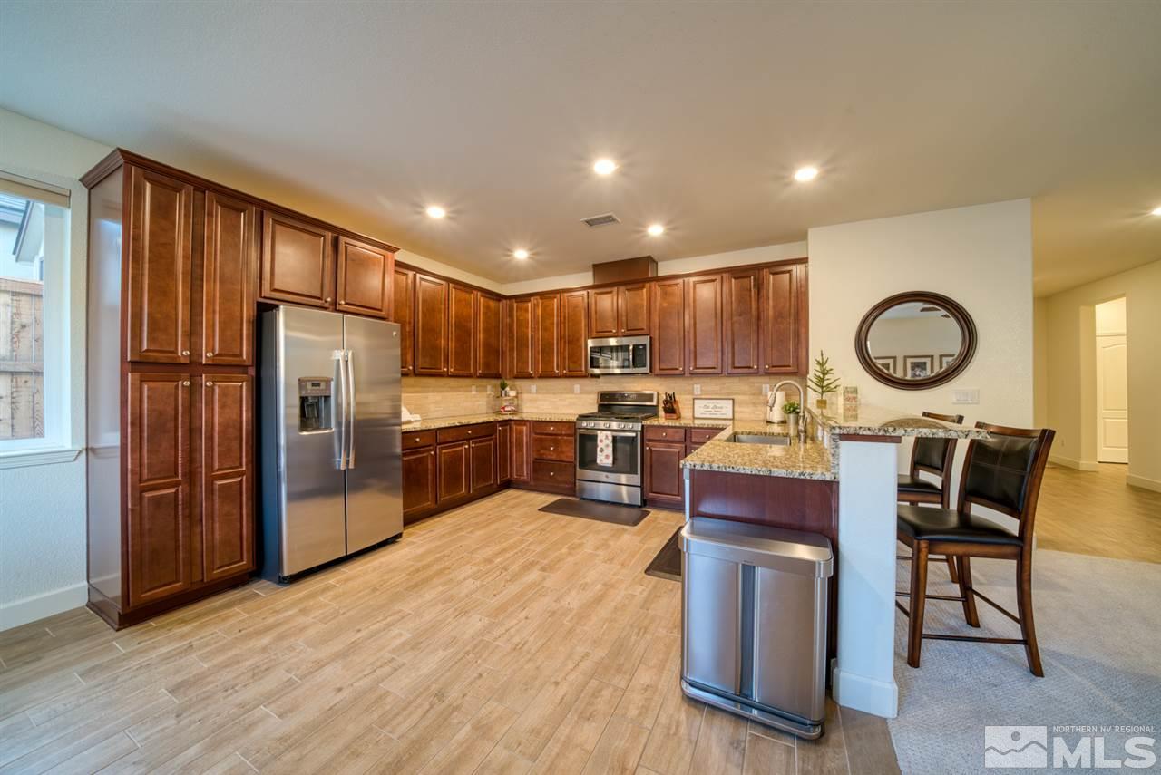 10380 Gold Mine Drive Reno, NV 89521 - Photo 8 of 23 a kitchen with granite countertop stainless steel appliances a refrigerator a stove top oven and a center island