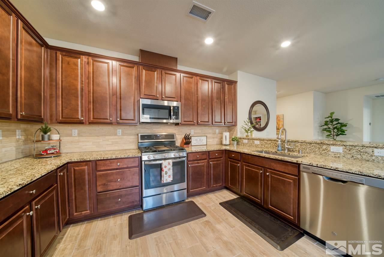 10380 Gold Mine Drive Reno, NV 89521 - Photo 9 of 23 a kitchen with stainless steel appliances granite countertop wooden cabinets a sink dishwasher a stove and a refrigerator