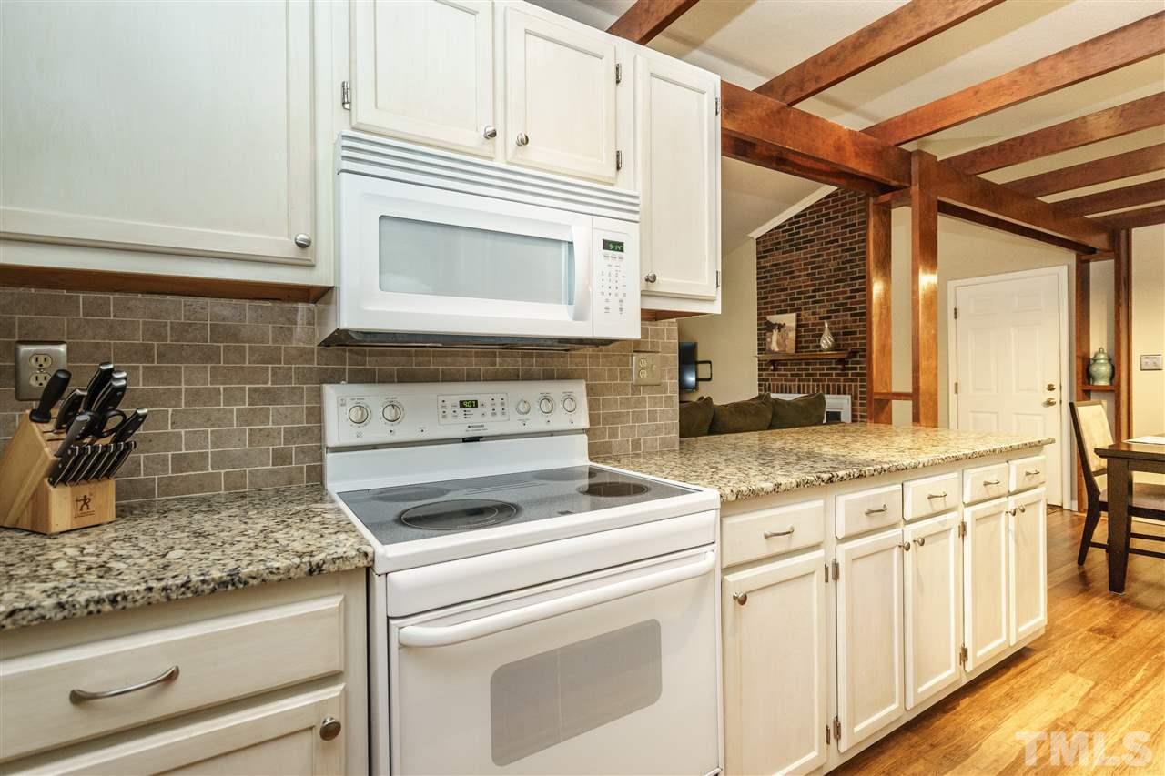 1300 Buckhorn Road Garner, NC 27529 - Photo 15 of 25 a kitchen with granite countertop white cabinets and white appliances