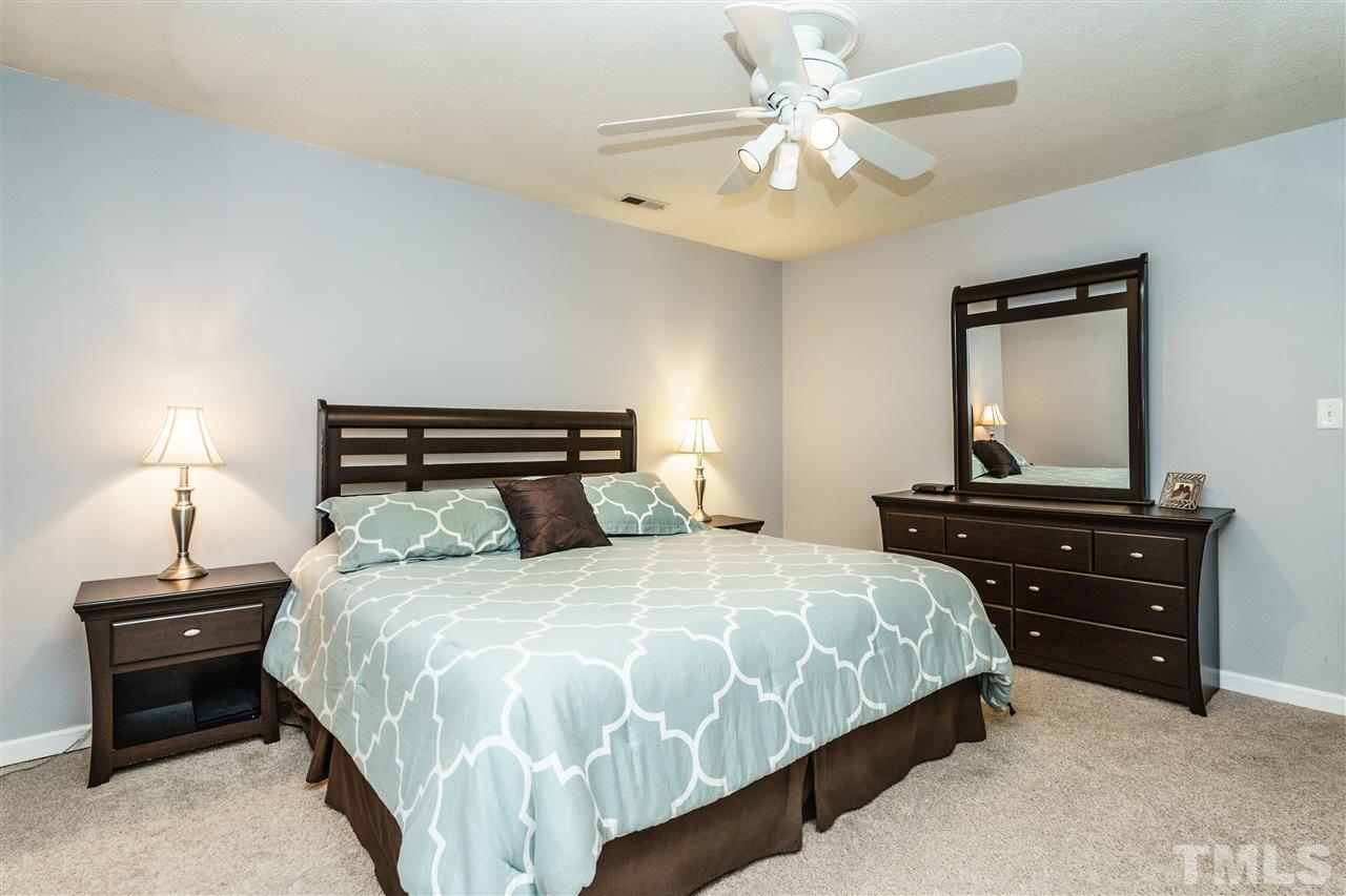 1300 Buckhorn Road Garner, NC 27529 - Photo 17 of 25 a bedroom with a bed and a lamp on a dresser