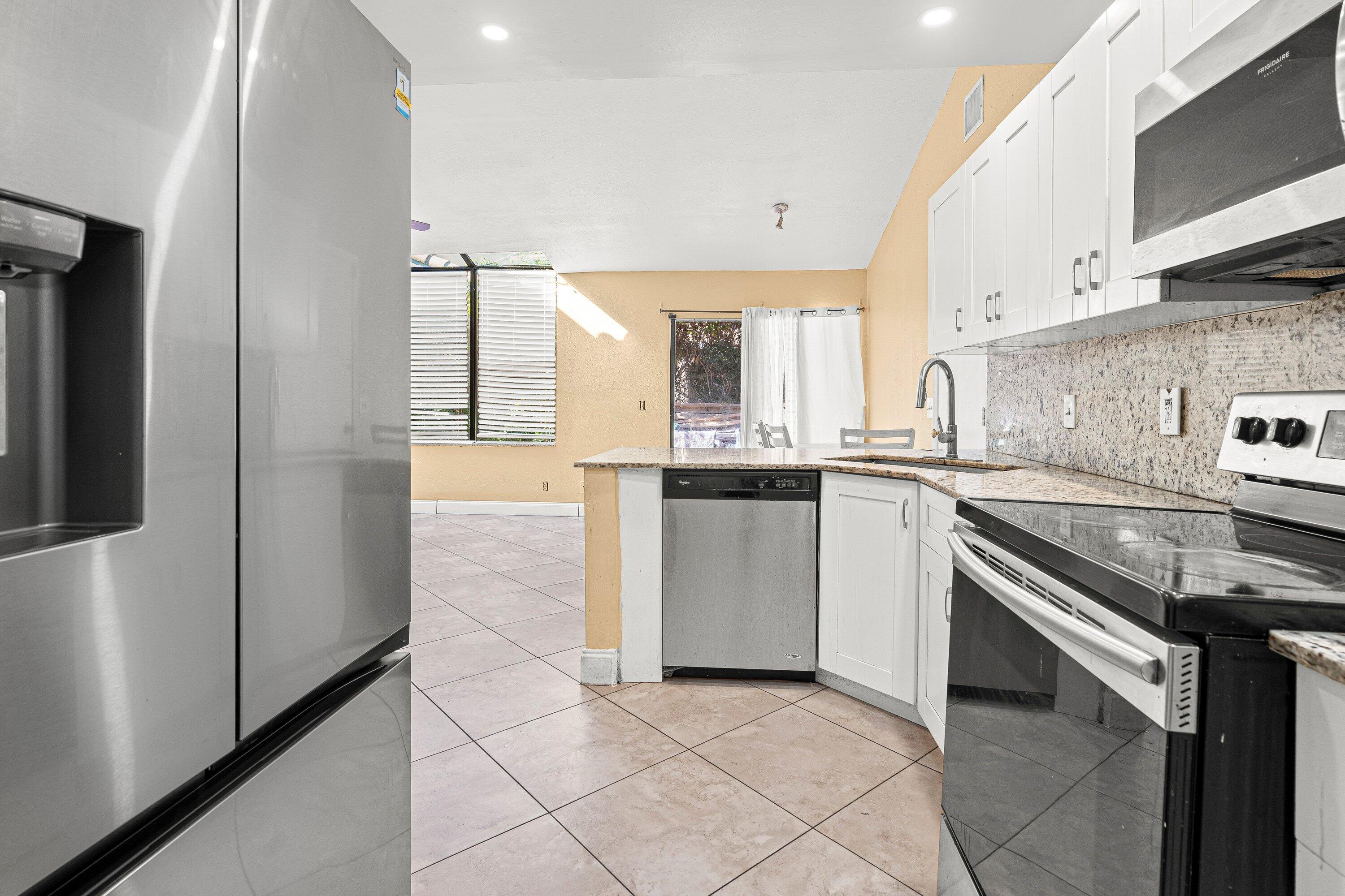 4134 Northwest 2nd Lane Delray Beach, FL 33445 - Photo 7 of 28 a kitchen with a stove a sink and a refrigerator