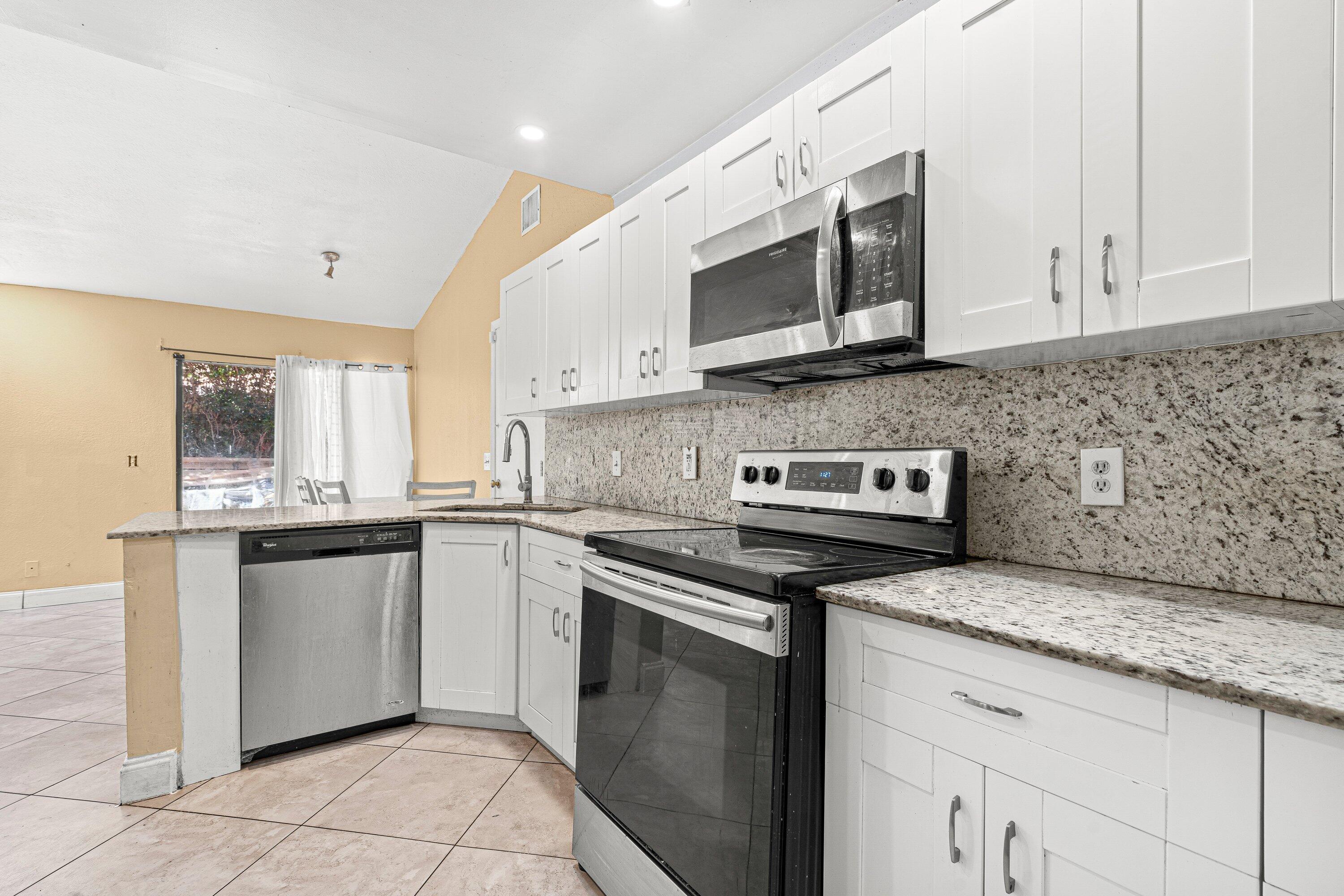 4134 Northwest 2nd Lane Delray Beach, FL 33445 - Photo 10 of 28 a kitchen with stainless steel appliances granite countertop a sink and a stove