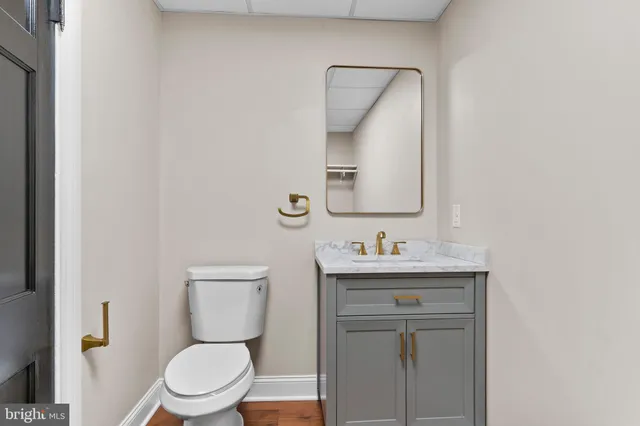 a bathroom with a toilet a sink a mirror and vanity