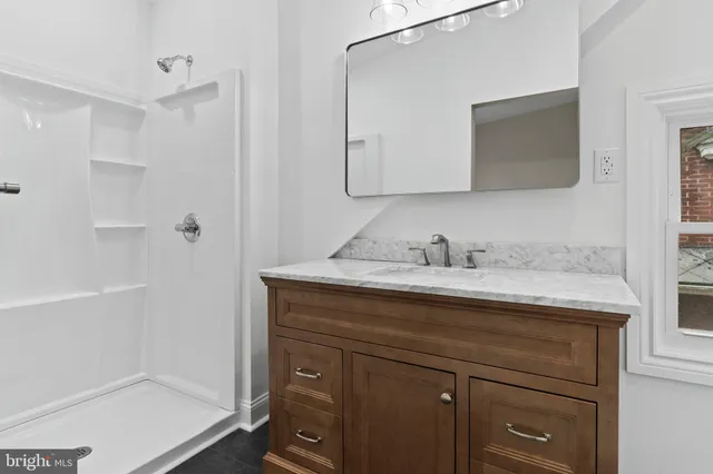 a bathroom with a granite countertop sink mirror and double