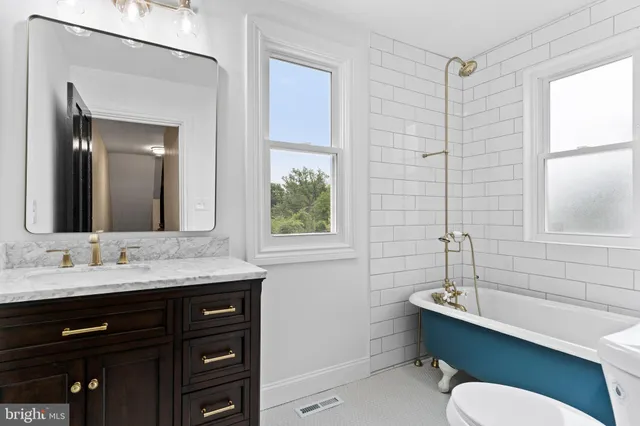 a bathroom with a granite countertop sink toilet a large mirror and shower