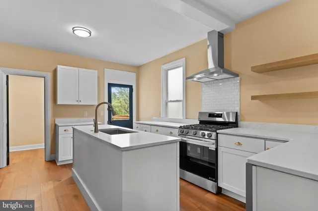a kitchen with granite countertop stainless steel appliances a stove a sink and a refrigerator