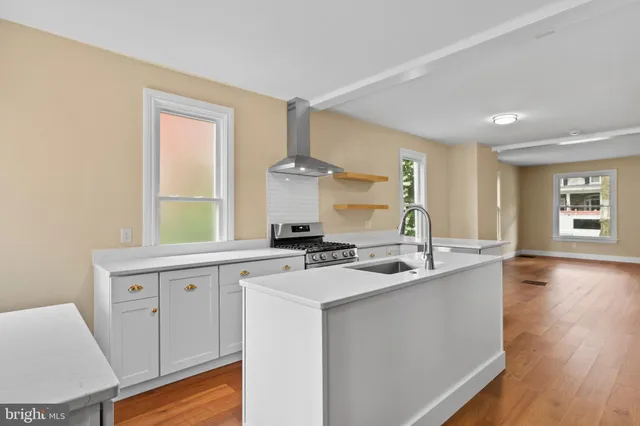 a kitchen with a sink cabinets and wooden floor