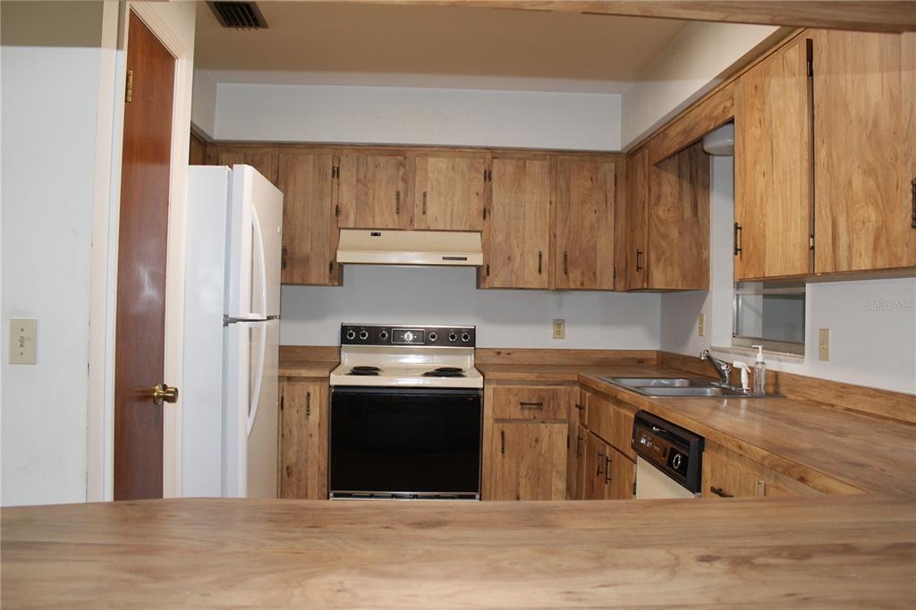 1638 Lamplighter Way Orlando, FL 32818 - Photo 11 of 25 a kitchen with stainless steel appliances granite countertop a stove a refrigerator and a sink